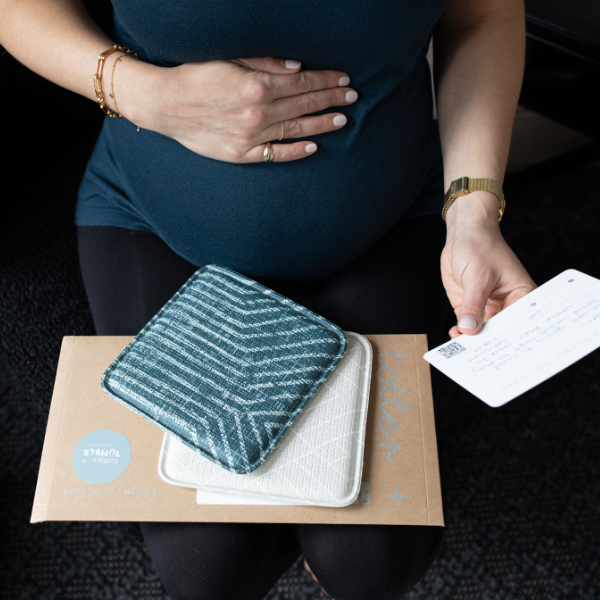 Pregnant mama opening baby shower gift that is for her 