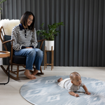 Mother watches baby on round Padded baby play mat that the whole family will love The Atlas is available in four sizes so you can choose the perfect size for your family space