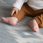 Close up of babies feet and pattern on Blue and beige baby play mat with stylish Ikat design ideal tumbling mat for babies and toddler for safe floor play thick memory foam adds comfort