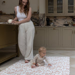 Mother and Baby relaxing in kitchen whilst using Totter and Tumble padded playmat