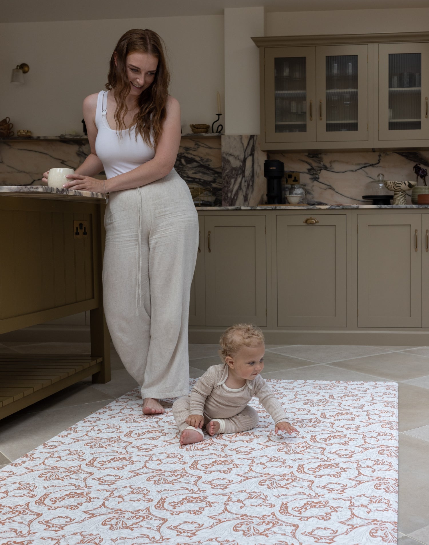 Mother and Baby relaxing in kitchen whilst using Totter and Tumble padded playmat