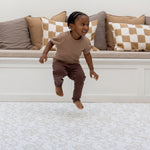 toddler jumping on cushioned play rug