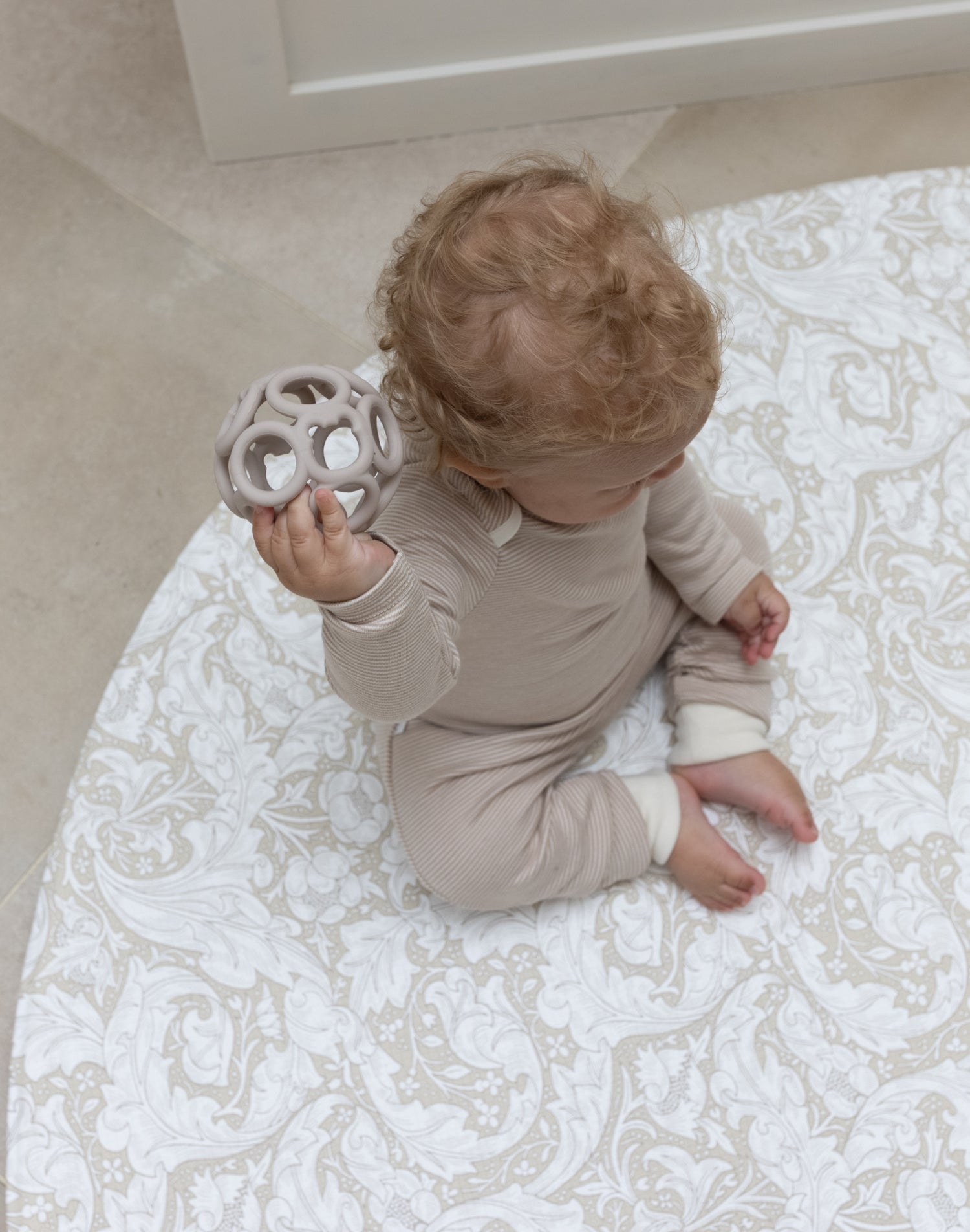 baby sitting on Totter and Tumble round neutral playmat