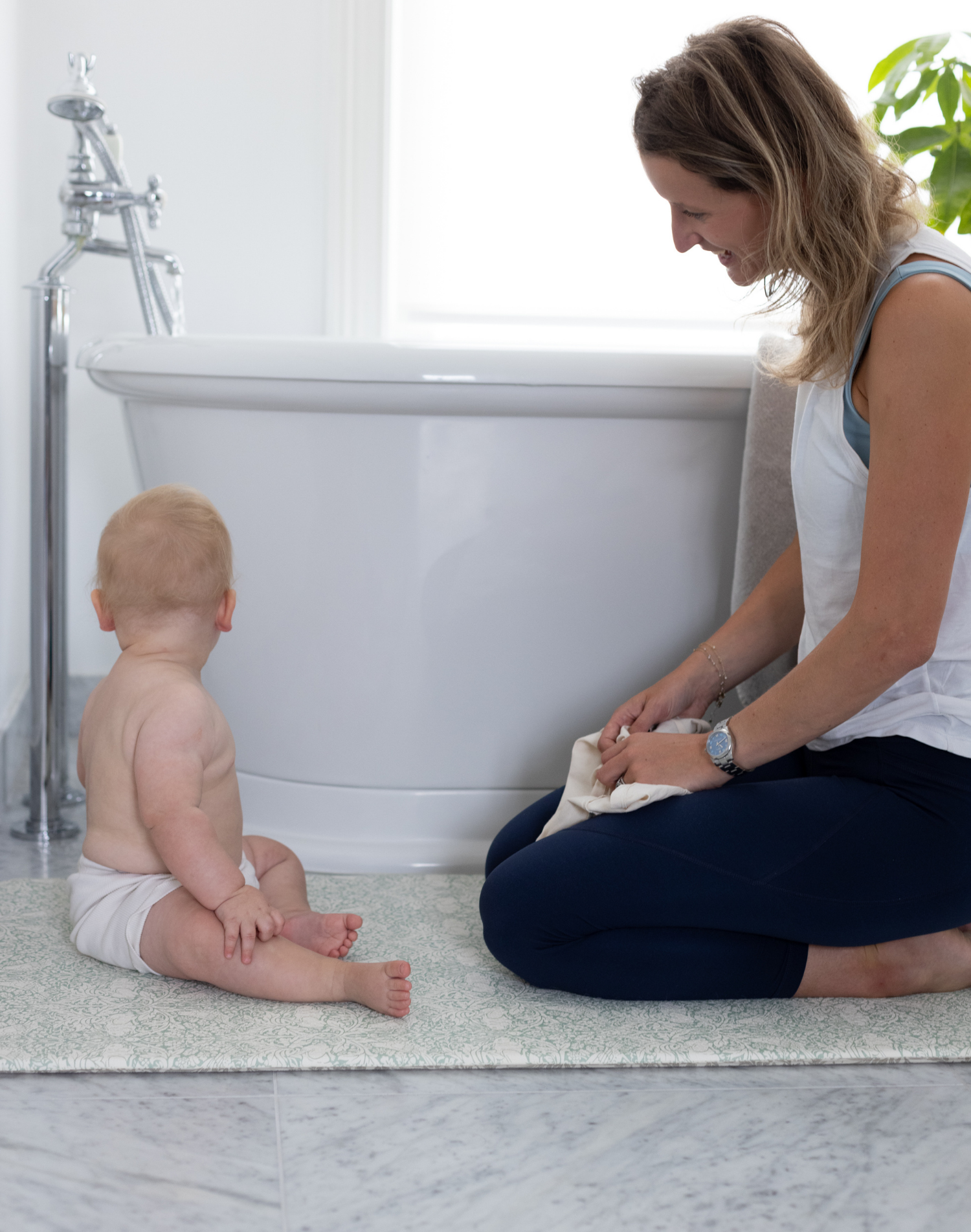 totter and tumble play runner beside the bath with mom and baby staying warm as play mat insulates from cold floor, non slip and comfortable great for bathroom