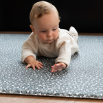 Baby enjoys tummy time on leopard print foam floor mat 