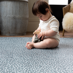 Baby enjoys playtime with wooden toy on extra large play mats