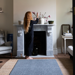 Lady stands next to big baby play mat with a modern motif of leopard print 