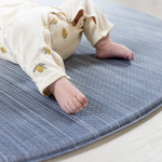 Close up of babies feet on The Kasuri a large padded floor mat by Totter and Tumble adds a stylish appeal to the space it is unrolled in with a one piece design that is washable so spillages are easy to clean the perfect play rug for the home