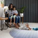 Mother and two children on Large round play mat for modern family homes The Kasuri is stylish with a gradient designs he navy blue play mat is perfect for anywhere in the home