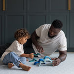 Man and boy playing on scalloped Mariner design play mat keeping comfortable on the memory foam and enjoying open play wooden toys 