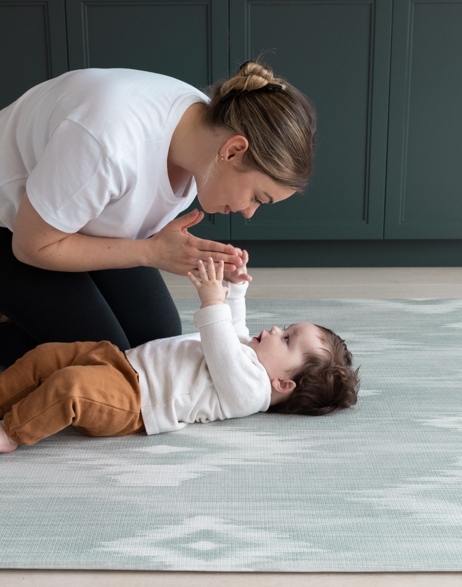 Mother and baby enjoying floor time on Thick memory foam mat for babies and adults designed for modern homes with artisan Ikat print in green and grey shades