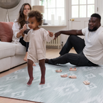 Family enjoying time together on The Odissi Totter & Tumble play mat is designed to look stylish in family homes with a sophisticated green and beige ikat design to complement modern decor