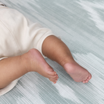 Close up of baby feet and design on Baby activity mat made from luxury memory foam to keep little ones comfortable on the floor