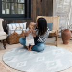 Mother and baby enjoying floor time on Large round tumble mat by Totter and Tumble with modern ikat design to look like a rug in your home