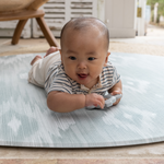 Round play mat for hard floors by Totter and Tumble so little ones don't feel the floor underneath with stylish green and beige ikat design for a stylish look 