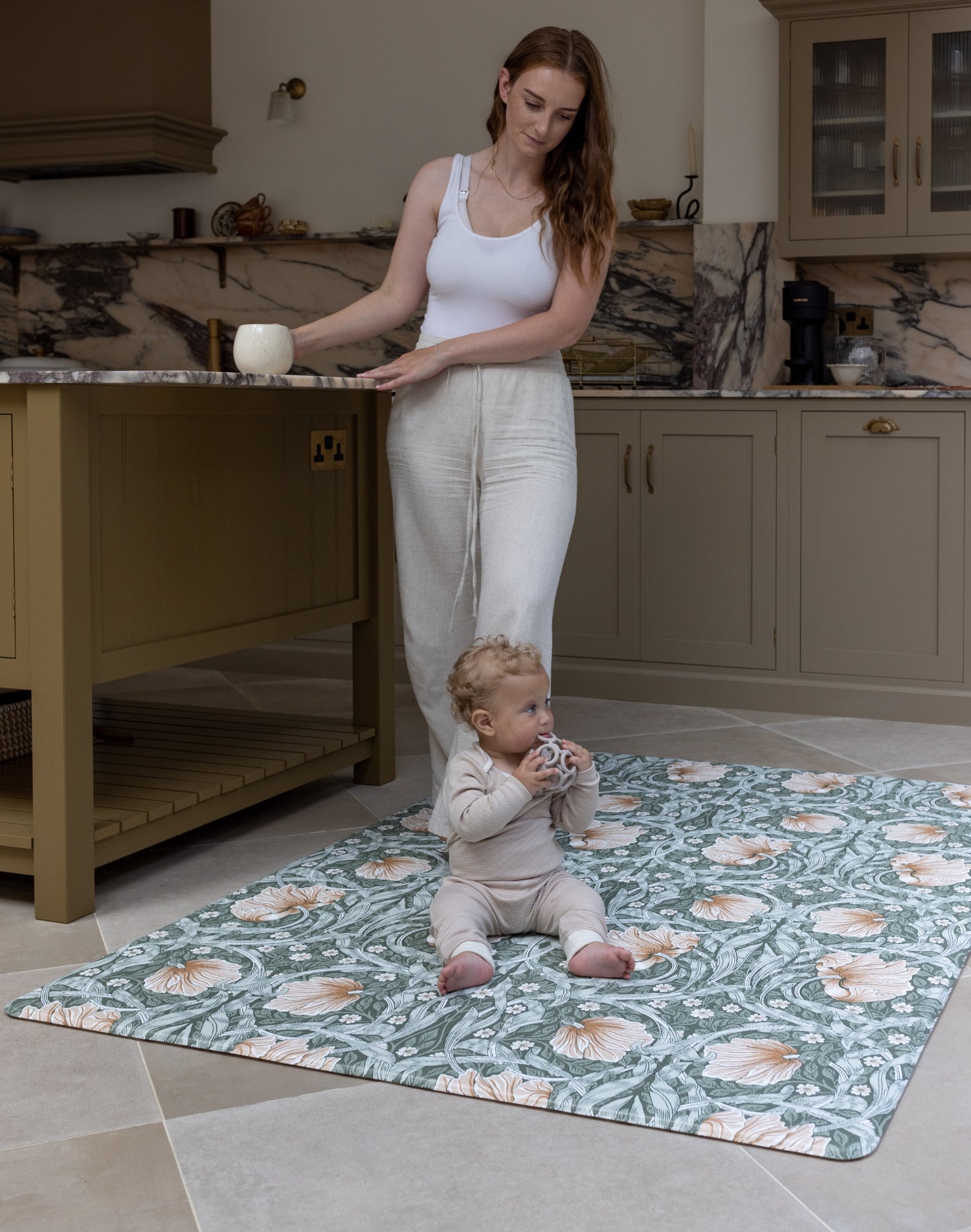 Mum and baby in family kitchen using padded playmat with Morris Pimpernel in green