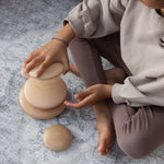 A child plays with stacking toys on a large foam playmat