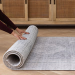 Hands roll out a rug-like large floor mat for babies that has two elegant designs on either side