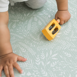 Little one crawls across the textured play mat with a gentle botanical print inspired by the english countryside 