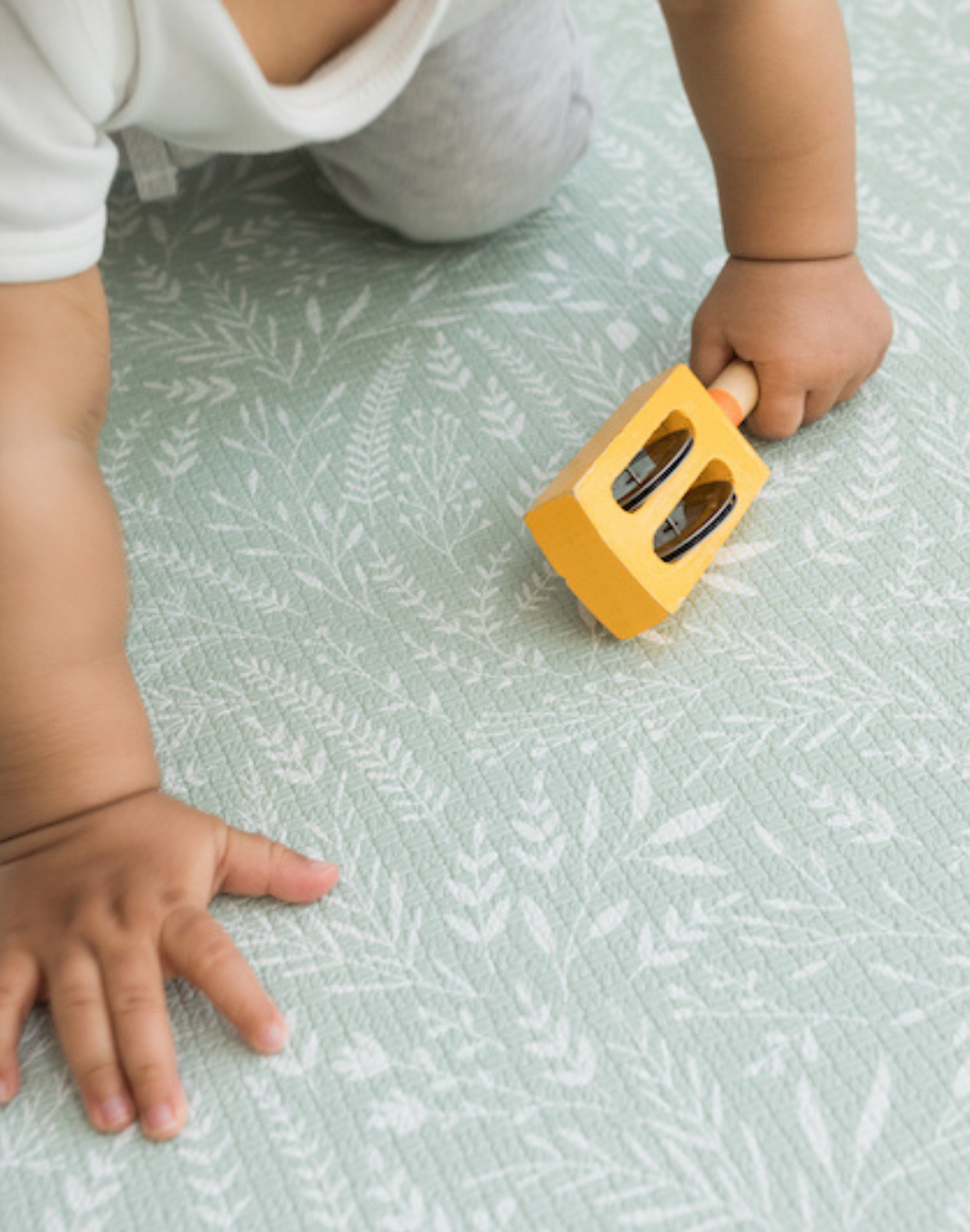 Little one crawls across the textured play mat with a gentle botanical print inspired by the english countryside 