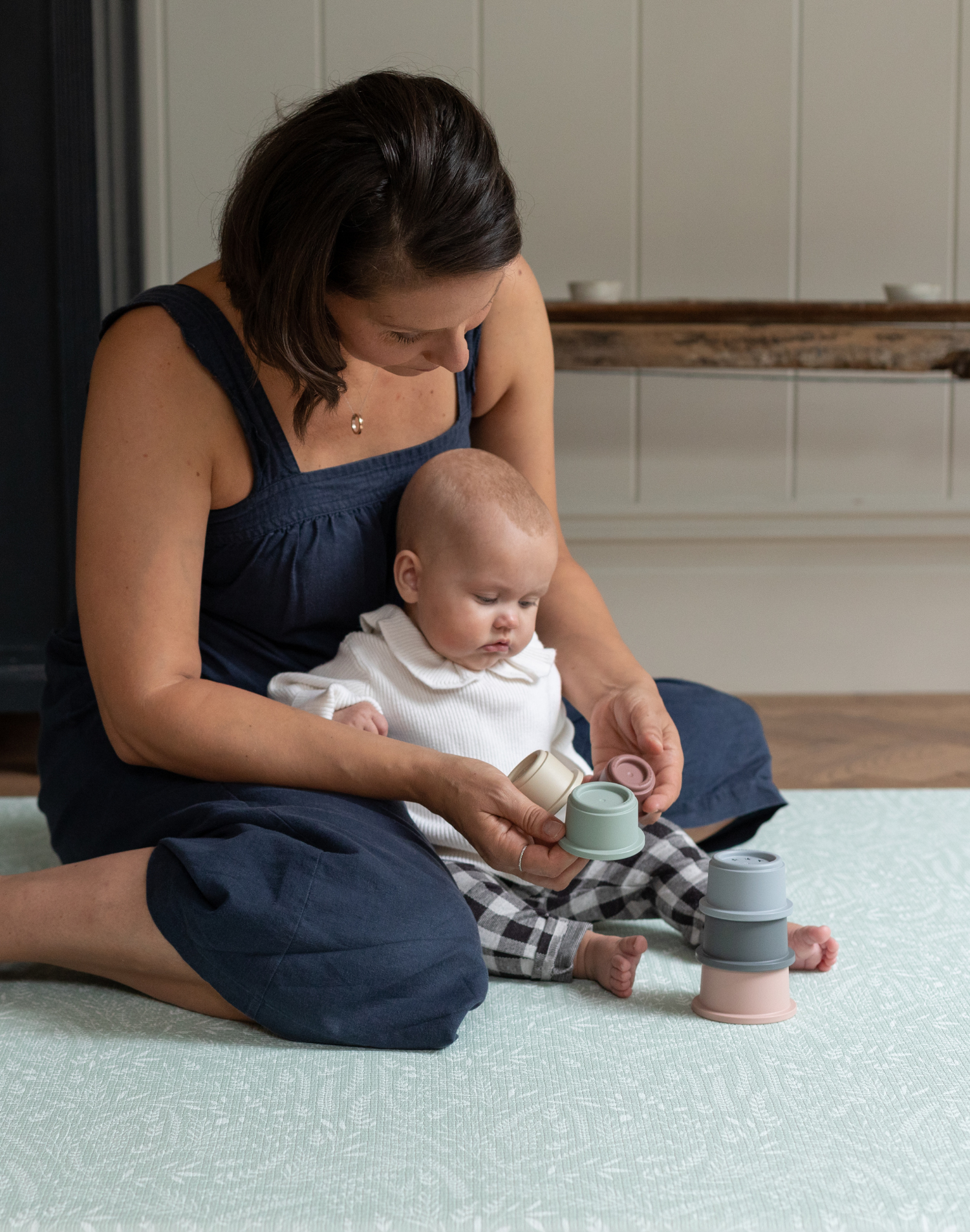 Mother and baby explore stacking cups on the groente speelmat that offers support and is extra comfortable 