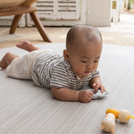 Baby enjoying tummy time on Large round tumble mat by Totter and Tumble with modern gradient design to look like a rug in your home