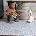 Little boy plays with soft toy on thickly padded playmat ideal for playtime