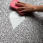 Cleaning milk on water resistant baby playmat with modern leopard print pattern