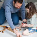 Father and daughter play on padded play mat with protective foam design and modern grey pattern 