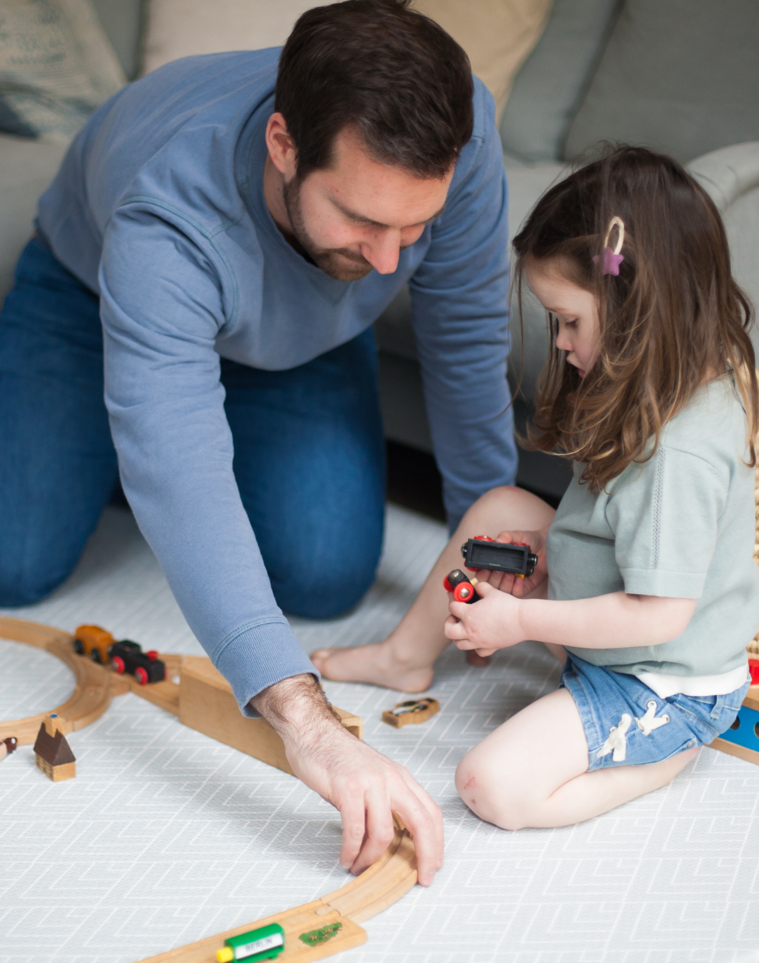 Father and daughter play on padded play mat with protective foam design and modern grey pattern 